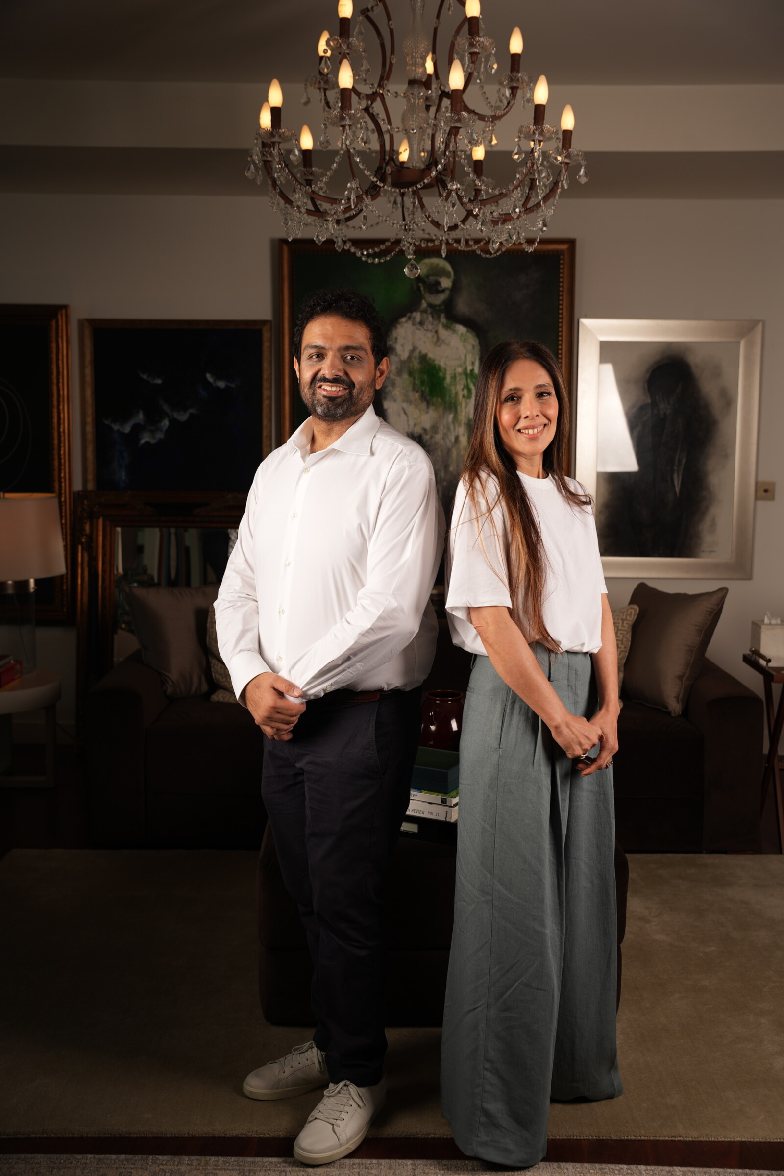 Bushra Khokhar and Tariq Ismail, co-founders of True Build Design, standing together and smiling in a warmly furnished studio interior
