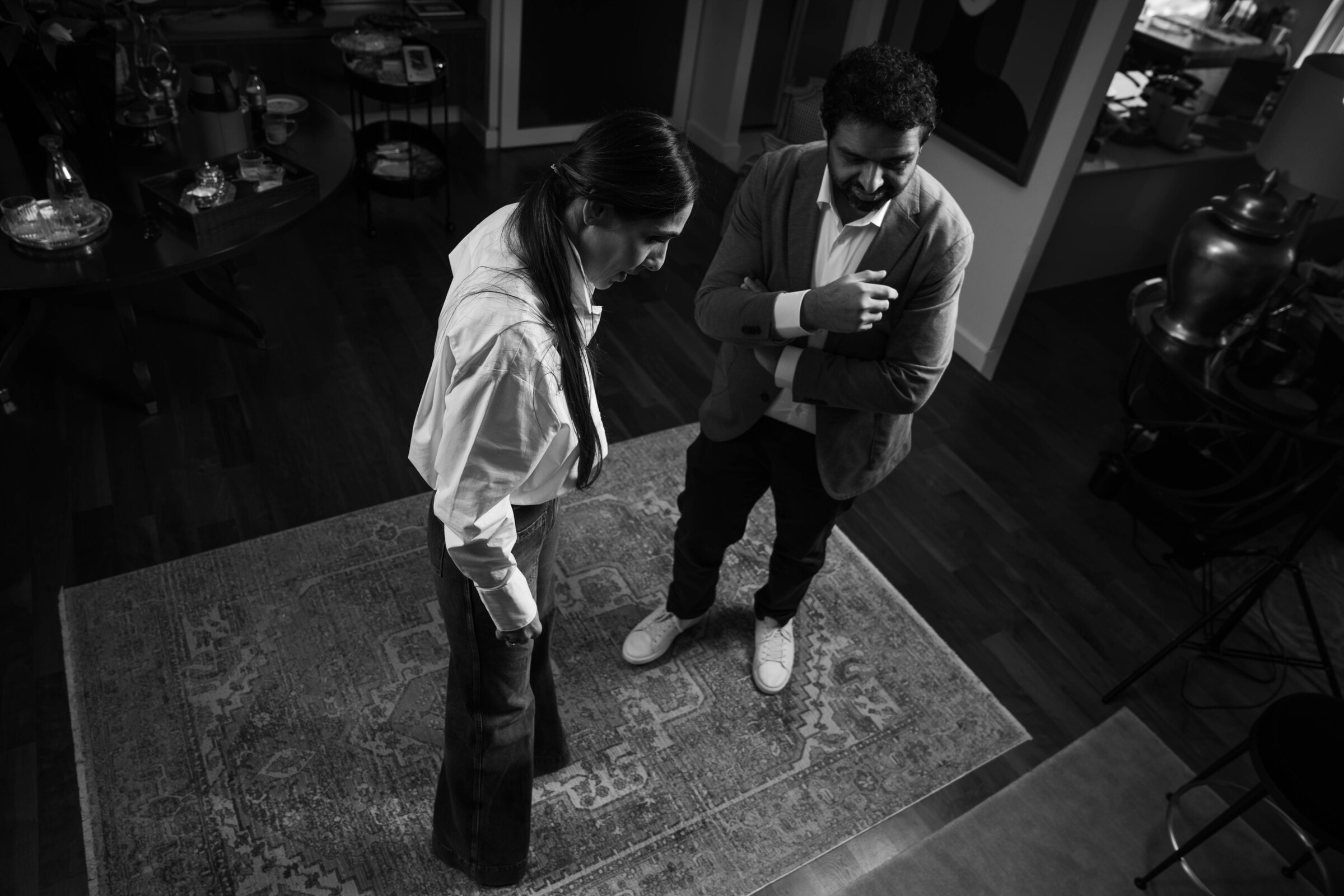 Bushra Khokhar and Tariq Ismail reviewing records together, seen from above on the studio rug