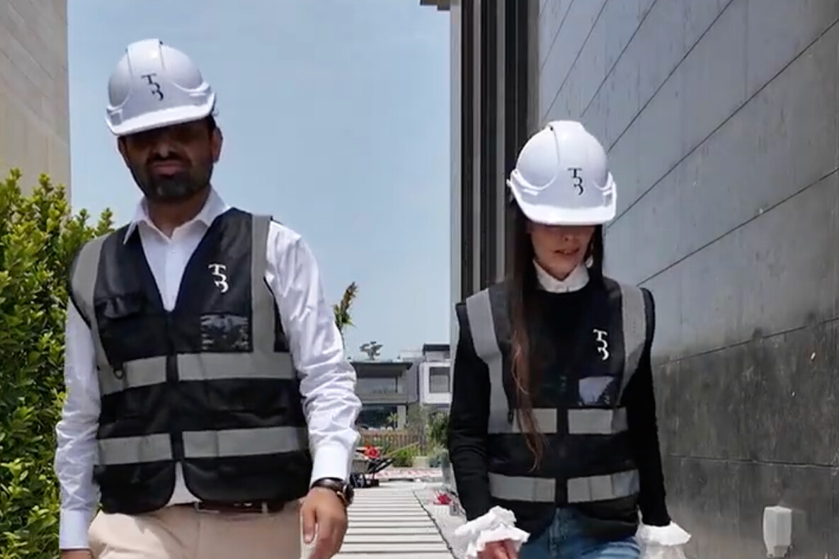 Bushra Khokhar and Tariq Ismail in True Build hard hats and hi-vis on a villa site